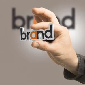 one-hand-holding-word-brand-beige-background-branding-concept-image-is-composition-2d-illustration-3d-rendering-photography